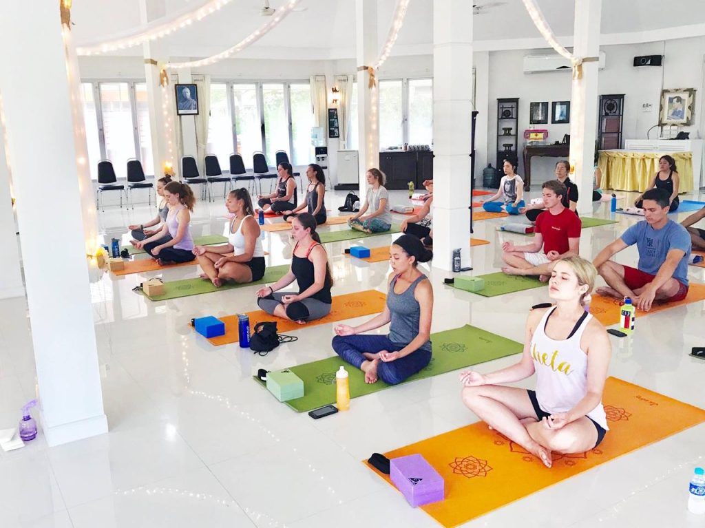 Previous retreat with students meditating on yoga mats